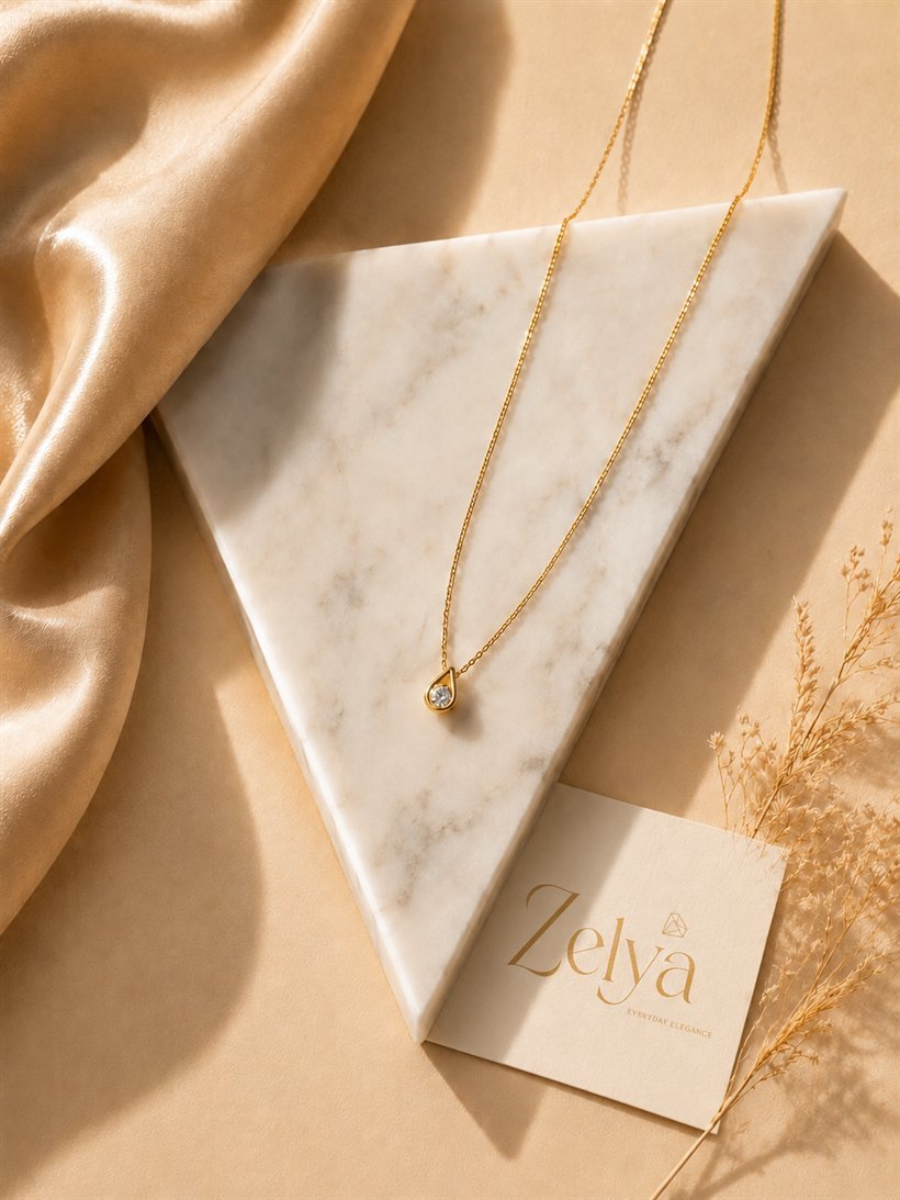 Collier doré délicat présenté sur un marbre ivoire